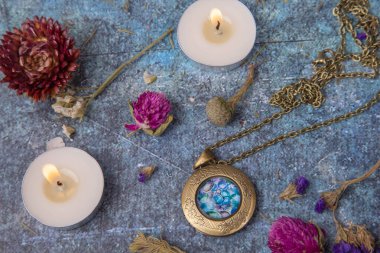 Madalyonu, mumları ve kurumuş çiçekleri olan düz yatak.