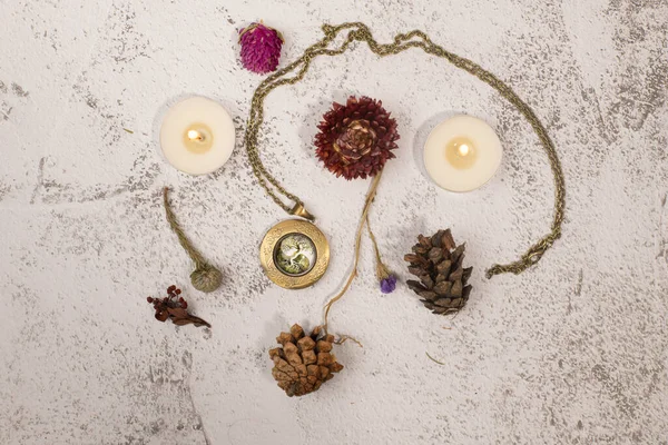 Flatlay with medallion, candles and dried flowers