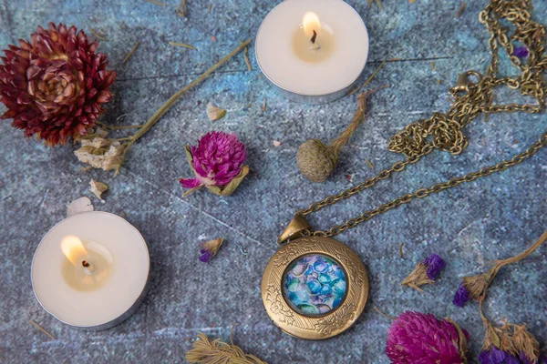 Madalyonu, mumları ve kurumuş çiçekleri olan düz yatak.