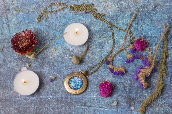 Madalyonu, mumları ve kurumuş çiçekleri olan düz yatak.
