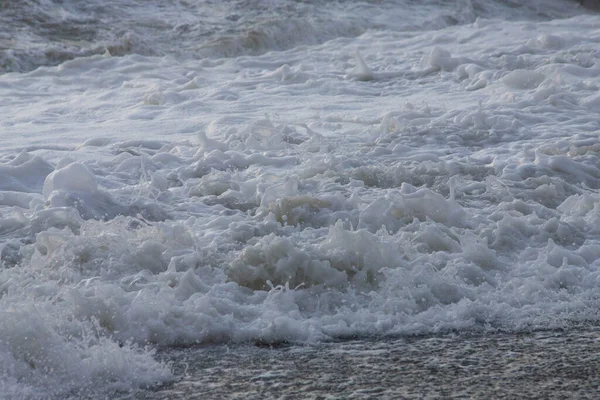 Vitt havsskum nära stranden närbild, vågor — Stockfoto