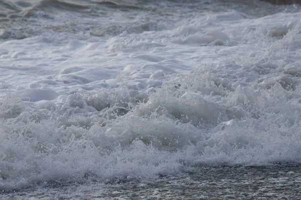 Vitt havsskum nära stranden närbild, vågor — Stockfoto