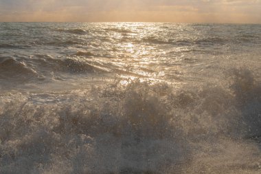 Günbatımının ışınlarında denizde fırtına büyük dalgalar, sprey