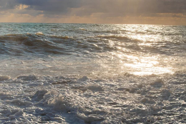 暴风雨在海面上的夕阳西下，大浪，浪花四溅 — 图库照片