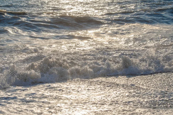 Storm on the sea in the rays of sunset big waves, spray — Stock Photo, Image