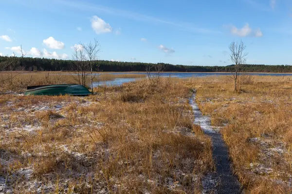 Bateau au bord du lac marécageux d'automne par une journée ensoleillée — Photo