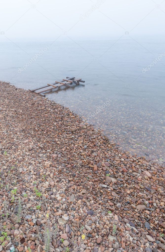 Wooden scaffold on stony coast.