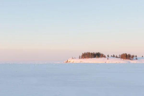 A fagyasztott sziklás partján tó téli reggel. — Stock Fotó