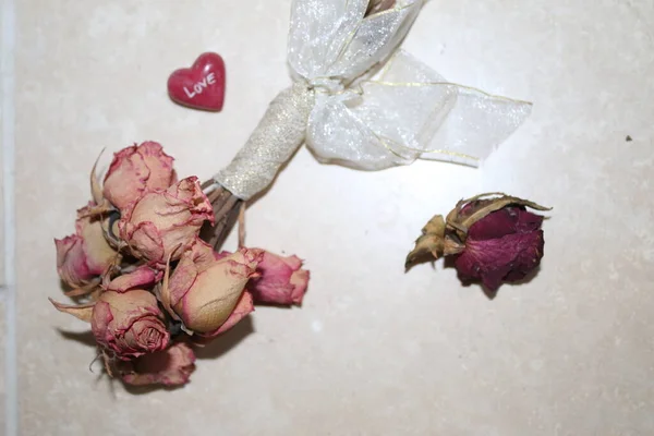 バレンタインデーのロマンチックな大規模な赤い愛の心の終わりに ヴィンテージのドライなバラの花束が結ばれていますクリームシルクリボン香りのバラの花びらと愛の贈り物として白い背景に鳥の目のビュー — ストック写真