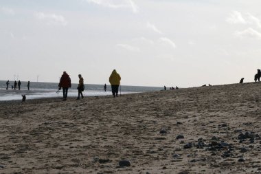 Geniş kumsal manzarası. Aile fertleri Winterton 'da yürüyor. Norfolk' ta, Doğu Anglia 'da.