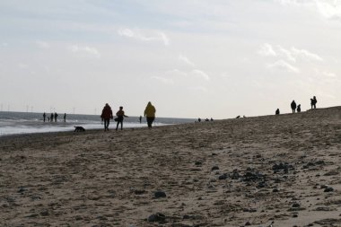 Geniş kumsal manzarası. Aile fertleri Winterton 'da yürüyor. Norfolk' ta, Doğu Anglia 'da.