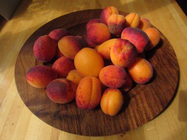 Olgun taze kayısılar, İngiltere 'nin kırsal kesimindeki ağaçtan toplanan lezzetli organik ev yapımı meyveler güneş ışığında ahşap kaseye dizilmiş mutfak yüzeyine düz bir görünüm sergiliyorlardı.