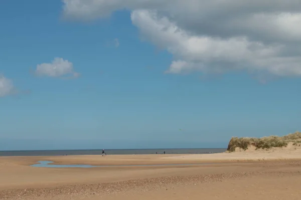 景色は広大な砂浜を越えて海に出る無人海岸線明るい夏の太陽の日に青い空の雲を持つ人はいませんウェルズ次はノーフォークの海東アングリアイングランド — ストック写真