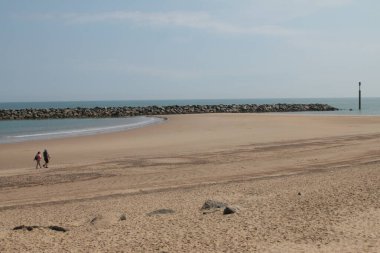Norfolk 'taki Sea Palling Körfezi' ndeki büyüleyici kumlu ve engin kumsal manzarası. Doğu Anglia uk. Yaz güneşinde mavi gökyüzü ve sakin gel-git okyanusu.