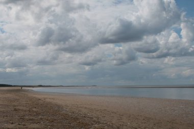Norfolk, Holkham 'daki engin kumlu plajın güzel manzarası. Doğu Anglia' da yaz tatilinde mavi gökyüzünde beyaz kabarık bulutlar.