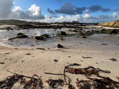 İskoçya 'nın güzel, vahşi kumsalı Uisken güzel kayalık ve kumlu sahil gündoğumu su havuzlarıyla güneş ışığını ufuktaki engin okyanusu vahşi yaşam ve kışın mavi gökyüzünü yansıtır.