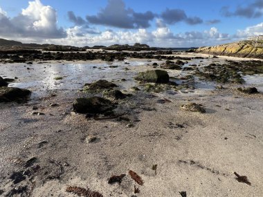 İskoçya 'nın güzel, vahşi kumsalı Uisken güzel kayalık ve kumlu sahil gündoğumu su havuzlarıyla güneş ışığını ufuktaki engin okyanusu vahşi yaşam ve kışın mavi gökyüzünü yansıtır.