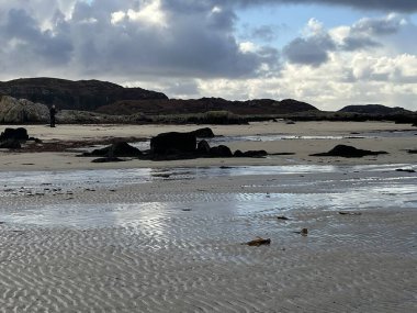 İskoçya 'nın güzel, vahşi kumsalı Uisken güzel kayalık ve kumlu sahil gündoğumu su havuzlarıyla güneş ışığını ufuktaki engin okyanusu vahşi yaşam ve kışın mavi gökyüzünü yansıtır.