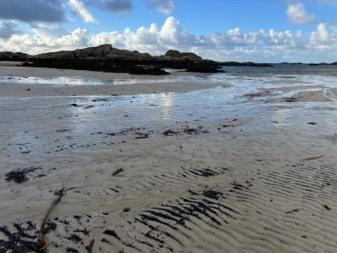 İskoçya 'nın güzel, vahşi kumsalı Uisken güzel kayalık ve kumlu sahil gündoğumu su havuzlarıyla güneş ışığını ufuktaki engin okyanusu vahşi yaşam ve kışın mavi gökyüzünü yansıtır.
