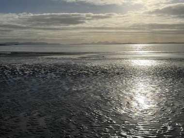 İskoçya 'nın güzel, vahşi kumsalı Uisken güzel kayalık ve kumlu sahil gündoğumu su havuzlarıyla güneş ışığını ufuktaki engin okyanusu vahşi yaşam ve kışın mavi gökyüzünü yansıtır.