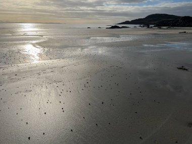 İskoçya 'nın güzel, vahşi kumsalı Uisken güzel kayalık ve kumlu sahil gündoğumu su havuzlarıyla güneş ışığını ufuktaki engin okyanusu vahşi yaşam ve kışın mavi gökyüzünü yansıtır.