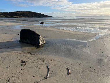 İskoçya 'nın güzel, vahşi kumsalı Uisken güzel kayalık ve kumlu sahil gündoğumu su havuzlarıyla güneş ışığını ufuktaki engin okyanusu vahşi yaşam ve kışın mavi gökyüzünü yansıtır.