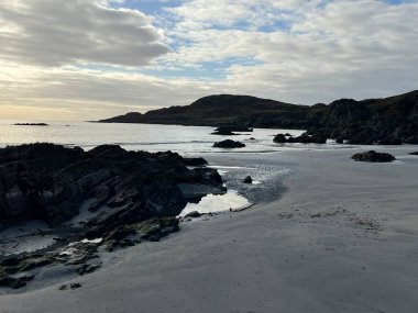 İskoçya 'nın güzel, vahşi kumsalı Uisken güzel kayalık ve kumlu sahil gündoğumu su havuzlarıyla güneş ışığını ufuktaki engin okyanusu vahşi yaşam ve kışın mavi gökyüzünü yansıtır.