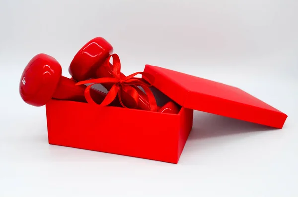 两个红色哑铃 带着丝带弓 开着红色盒子 白色背景 情人节的概念 健康的生活方式 热爱运动 — 图库照片