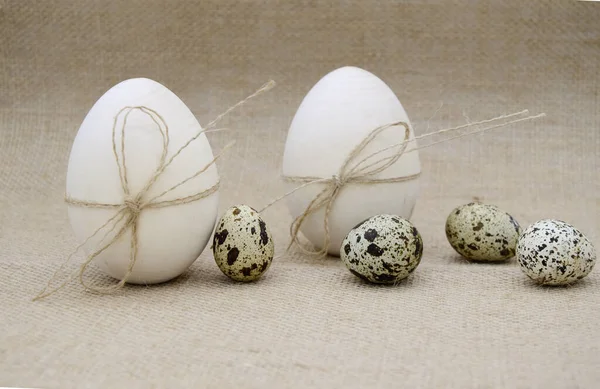 İp yaylı iki tahta yumurta, çuval bezi arkaplanda guail yumurtası. Paskalya, doğum kavramı.