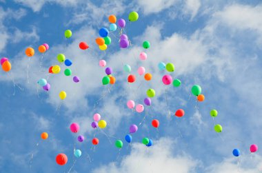 Bir sürü renkli balon mavi gökyüzüne karşı uçuyor ve kopya alanı olan bulutlar. Tatil kavramı, Çocuk Günü, okul ve anaokulu için son çağrı, doğum günü..