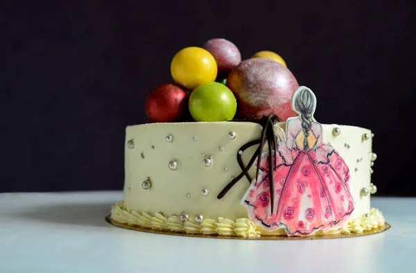 カラフルな風船と女の子がテーブルの上に彼女と一緒に立って白いケーキ 誕生日 記念日 — ストック写真