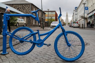 Reykjavik 'te sokak bariyeri olarak mavi bisiklet, arka planda Hallgrimskirkja çan kulesi, İzlanda