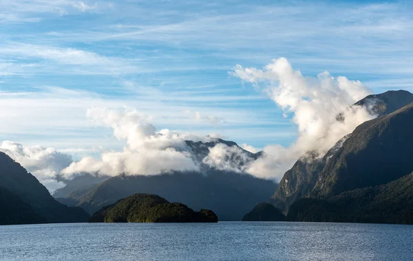 太陽は疑い深い音の上に昇る雲は山の上に低くぶら下がっているニュージーランドの南の島 — ストック写真