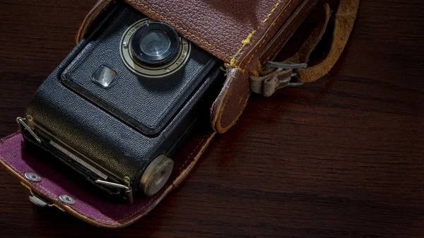 Antique camera in case on wood table — Stock Photo, Image