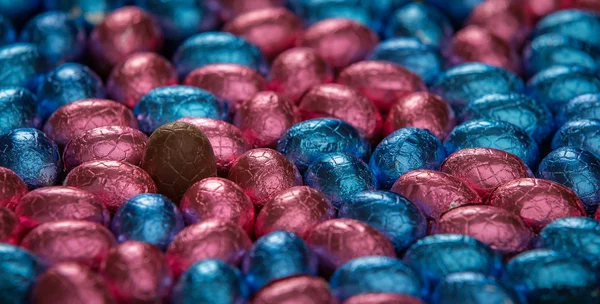 Choklad påskägg omgivande ett oförpackat stående ägg — Stockfoto
