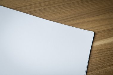 Sheets of blank paper on wooden desk clipart