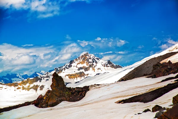 Sníh na horách proti modré obloze v oblacích. Elbrus region. Kavkaz. — Stock fotografie
