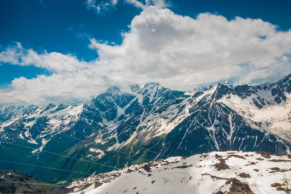 雲の青空と山に雪が降る。Elbrus の領域。コーカサス. — ストック写真