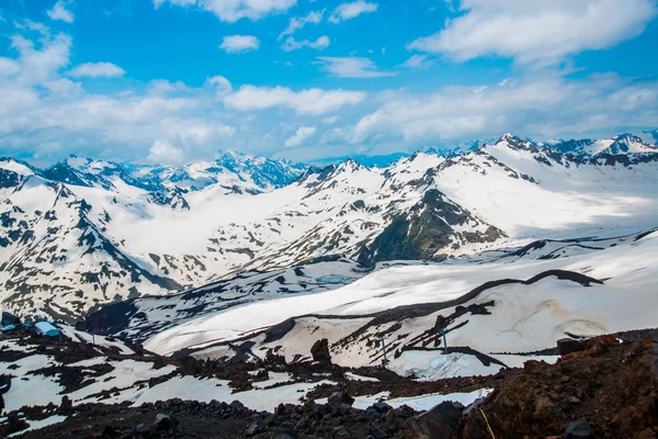 Snö på bergen mot den blå himlen i molnen. Elbrus regionen. Kaukasus. — Stockfoto