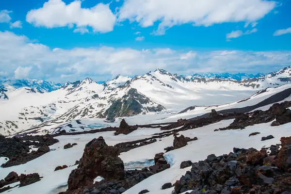 Snö på bergen mot den blå himlen i molnen. Elbrus regionen. Kaukasus. — Stockfoto