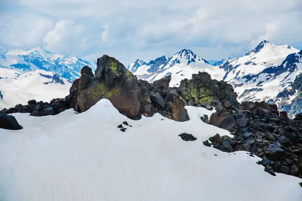 Neve nas montanhas contra o céu azul nas nuvens.A região do Elbrus.O Cáucaso . — Fotografia de Stock