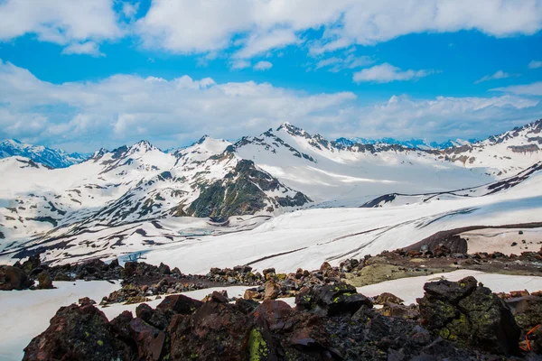 Χιόνι στα βουνά κατά το γαλάζιο του ουρανού στα σύννεφα. Περιοχή "Elbrus". Ο Καύκασος. — Φωτογραφία Αρχείου