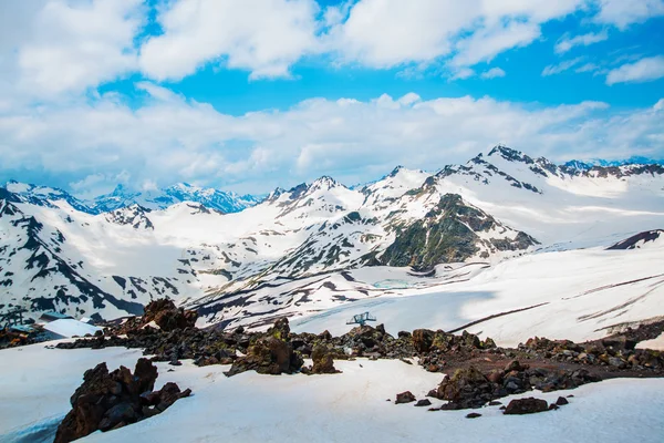 Snö på bergen mot den blå himlen i molnen. Elbrus regionen. Kaukasus. — Stockfoto