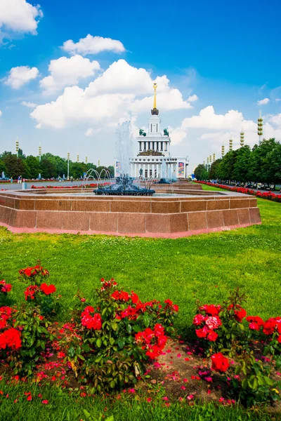 Central pavilion, exhibition center on the blue sky background. Red flowers. Fountain. ENEA,VDNH,VVC. Moscow, Russia. — Stock Photo, Image