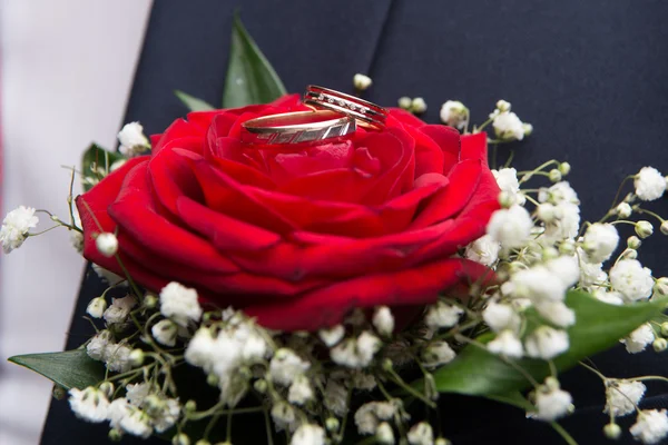 结婚戒指躺在红色玫瑰花上 — 图库照片