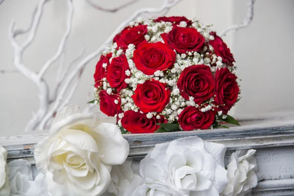 Anillos de compromiso y ramo nupcial de rosas rojas . — Foto de Stock