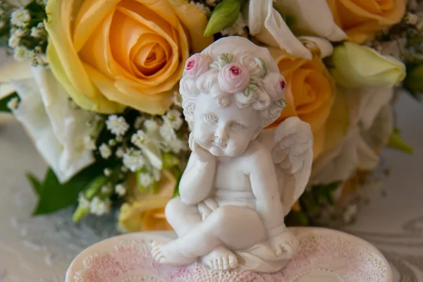 두 개의 골드 웨딩 링은 오렌지 장미와 흰색 꽃의 신부의 꽃다발 근처 천사 조각장미 모양의 플래터에 누워. — 스톡 사진