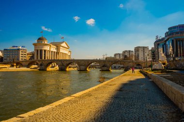 Osmanlı Taşı Köprüsü ve Vardar Nehri 'nin etrafındaki binalar. Makedon başkenti Üsküp şehir merkezinden görüntü.