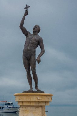 Epifani anıtı, sağ elinde haç tutan bir adamın bronz heykeli. UNESCO Dünya Mirası Alanı