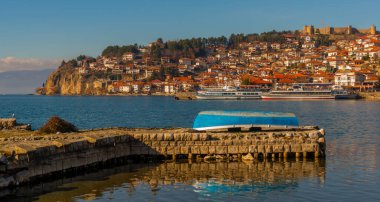 OHRID, NORTH MACEDONIA: Ohri 'deki iskelede eski mavi bir ahşap balıkçı teknesi var. UNESCO Dünya Mirası Alanı.